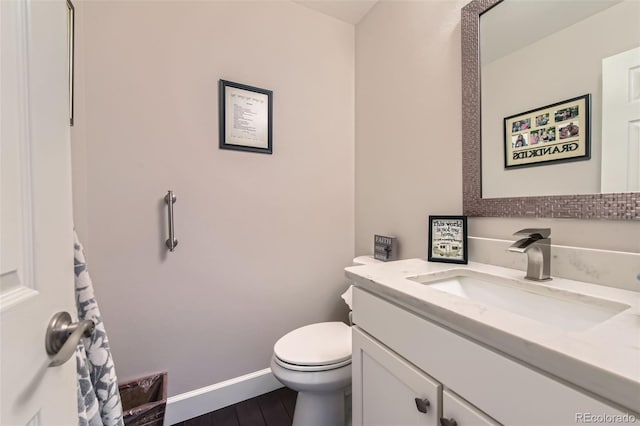 bathroom featuring vanity, hardwood / wood-style flooring, and toilet