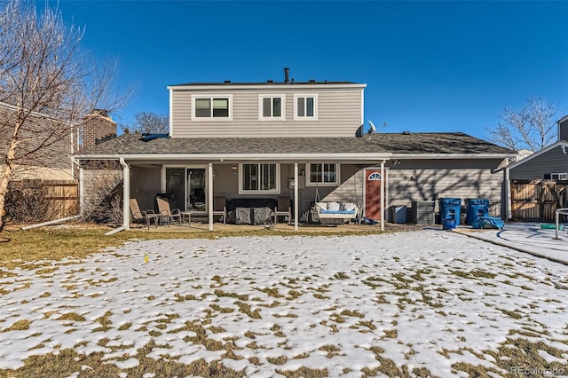 snow covered rear of property featuring a patio area