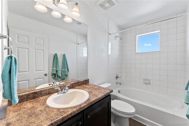 bathroom featuring visible vents, toilet, vanity, and bathtub / shower combination