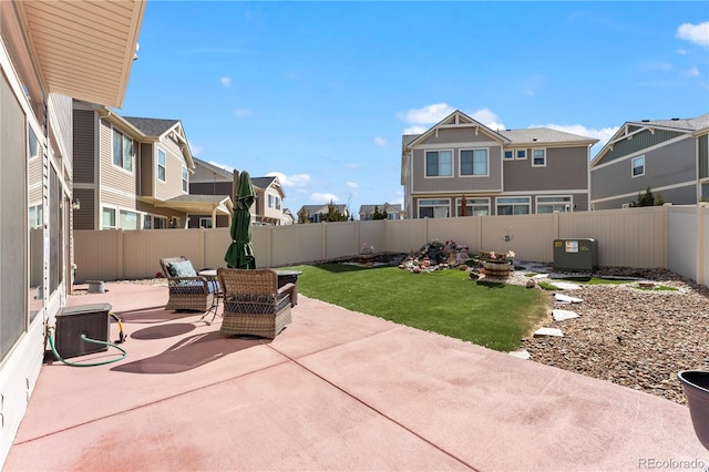 view of patio featuring central air condition unit, a residential view, and a fenced backyard