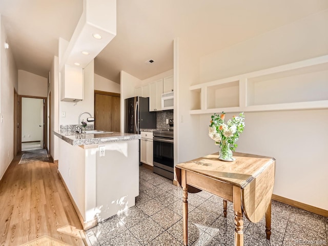 40 Cove Blvd Unit G40, Dillon, CO 80435 - kitchen featuring stainless steel electric range oven, white microwave, a sink, white cabinetry, and lofted ceiling