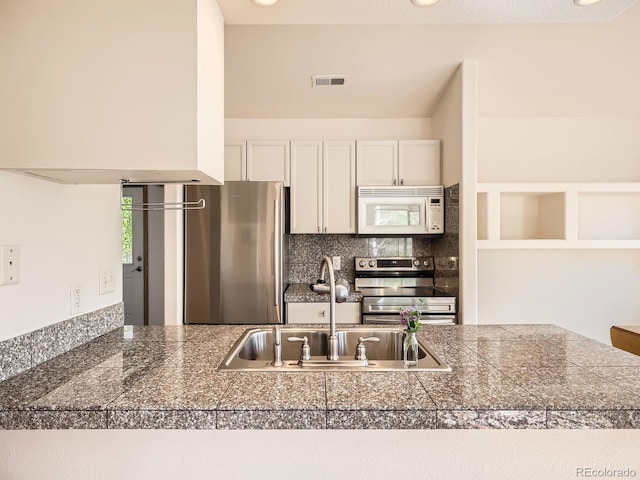 40 Cove Blvd Unit G40, Dillon, CO 80435 - kitchen with tile countertops, appliances with stainless steel finishes, a sink, tasteful backsplash, and white cabinets