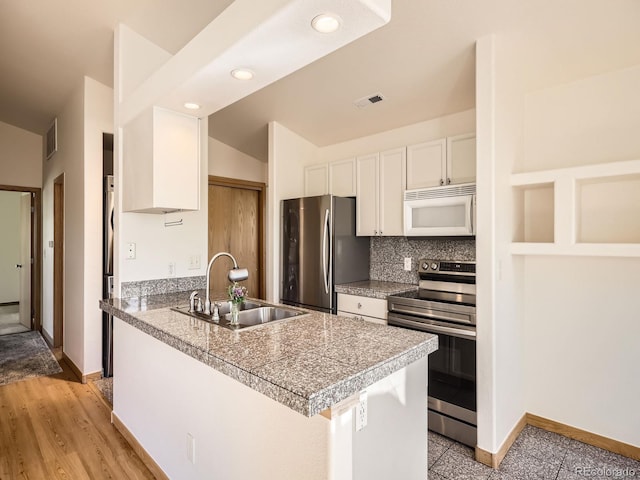 40 Cove Blvd Unit G40, Dillon, CO 80435 - kitchen featuring appliances with stainless steel finishes, tile counters, a sink, white cabinetry, and baseboards