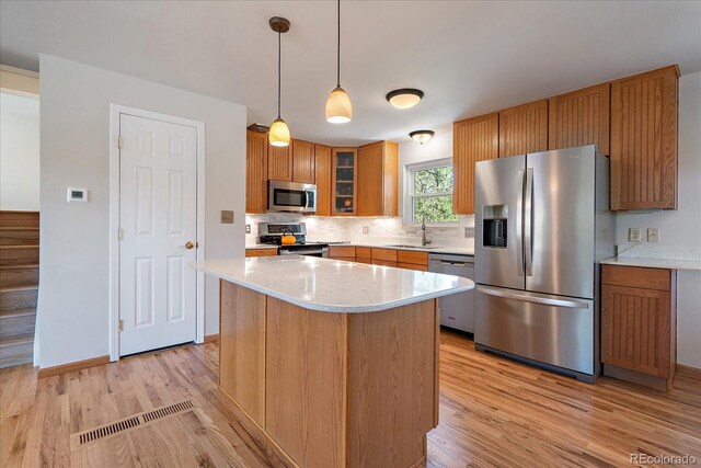 29827 Gigi Rd, Evergreen, CO 80439 - kitchen with stainless steel appliances, a sink, light wood-type flooring, light countertops, and tasteful backsplash