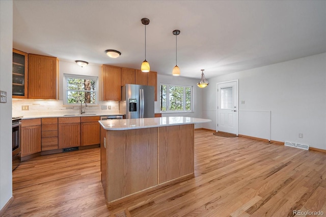 29827 Gigi Rd, Evergreen, CO 80439 - kitchen with stainless steel fridge with ice dispenser, a sink, light countertops, backsplash, and healthy amount of natural light