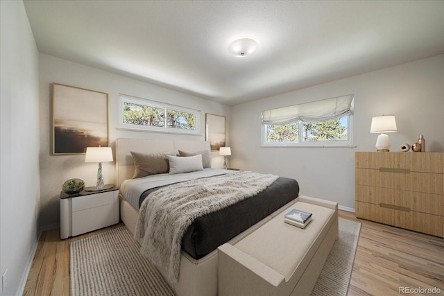 29827 Gigi Rd, Evergreen, CO 80439 - bedroom featuring multiple windows, baseboards, and light wood finished floors