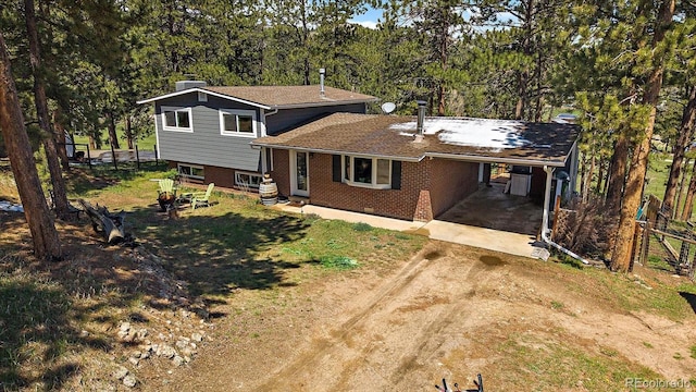 29827 Gigi Rd, Evergreen, CO 80439 - split level home featuring dirt driveway, brick siding, an attached carport, and a chimney
