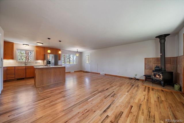 29827 Gigi Rd, Evergreen, CO 80439 - unfurnished living room featuring light wood-type flooring and a wood stove