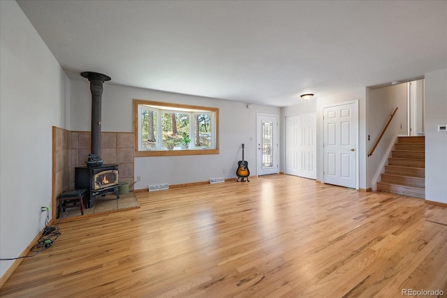 29827 Gigi Rd, Evergreen, CO 80439 - unfurnished living room with a wood stove, wood finished floors, and stairway