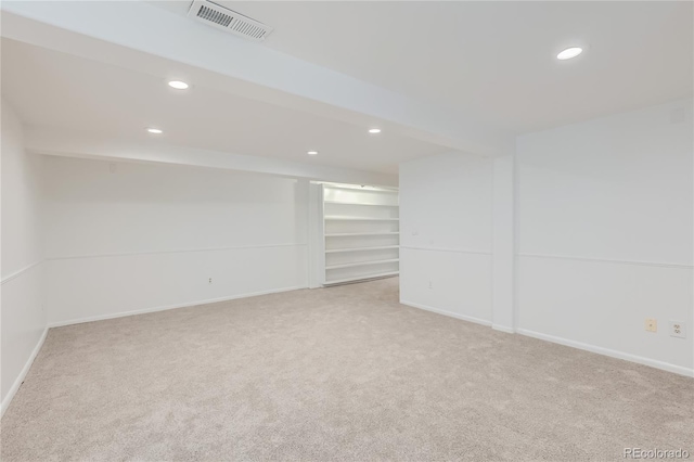 unfurnished room with beamed ceiling and light colored carpet