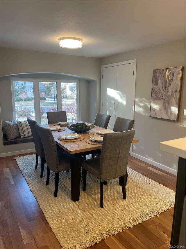 dining space with dark wood-type flooring