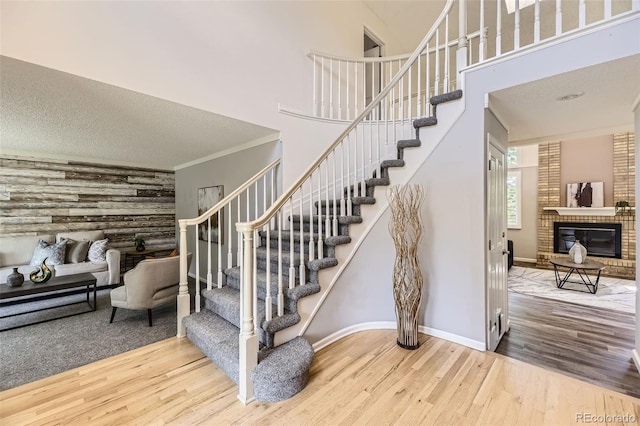 16257 E Belleview Pl, Centennial, CO 80015 - stairs featuring wood finished floors, a fireplace, baseboards, crown molding, and a high ceiling