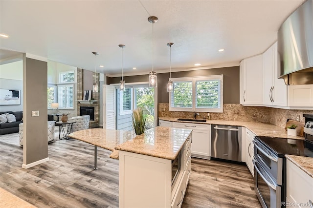 16257 E Belleview Pl, Centennial, CO 80015 - kitchen featuring appliances with stainless steel finishes, a sink, extractor fan, wood finished floors, and light stone countertops