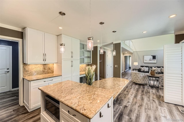 16257 E Belleview Pl, Centennial, CO 80015 - kitchen featuring stainless steel microwave, dark wood-type flooring, decorative backsplash, light stone counters, and white cabinets