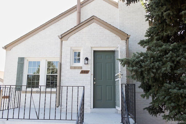 entrance to property featuring brick siding