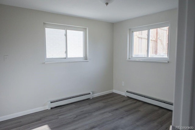 spare room featuring plenty of natural light, wood finished floors, and a baseboard radiator