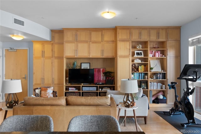 living area with visible vents and wood finished floors