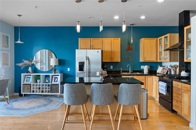kitchen featuring black range with gas cooktop, a kitchen island, dark countertops, a sink, and stainless steel fridge with ice dispenser