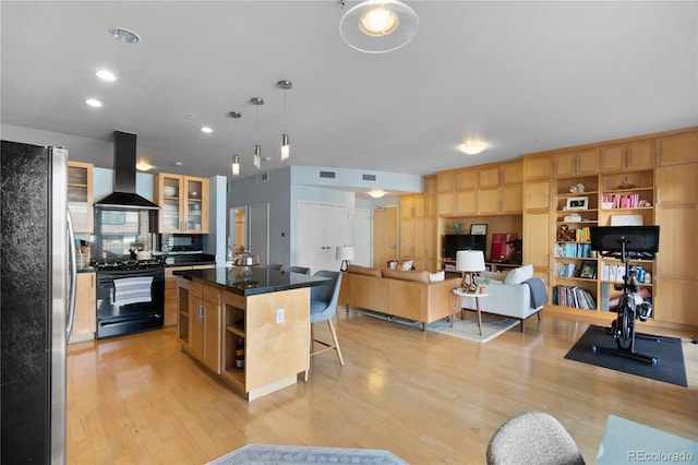 kitchen featuring open shelves, a kitchen breakfast bar, light wood-style flooring, range hood, and black appliances