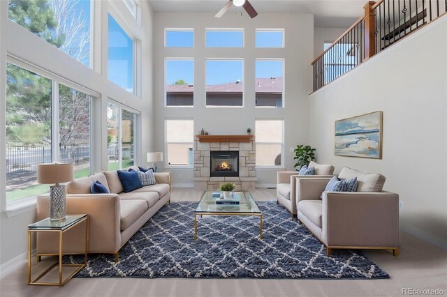 7436 Centennial Glen Dr, Colorado Springs, CO 80919 - living room featuring ceiling fan, baseboards, a fireplace, and a towering ceiling