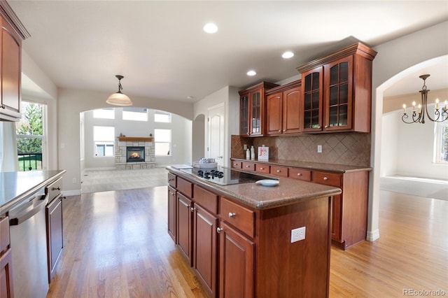 7436 Centennial Glen Dr, Colorado Springs, CO 80919 - kitchen with stainless steel dishwasher, black electric cooktop, arched walkways, light wood-type flooring, and open floor plan