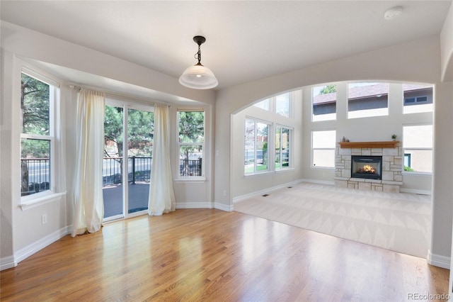 7436 Centennial Glen Dr, Colorado Springs, CO 80919 - unfurnished living room featuring wood finished floors, baseboards, and a stone fireplace
