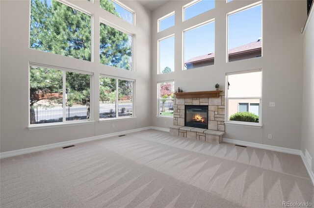 7436 Centennial Glen Dr, Colorado Springs, CO 80919 - unfurnished living room with carpet flooring, a fireplace, a towering ceiling, and baseboards