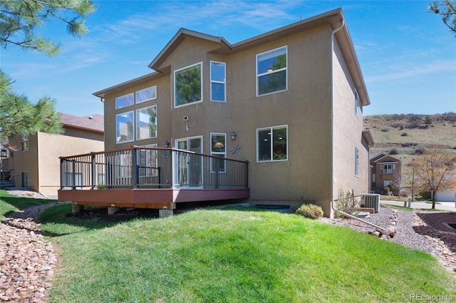 7436 Centennial Glen Dr, Colorado Springs, CO 80919 - back of house featuring stucco siding, a wooden deck, central AC, and a lawn