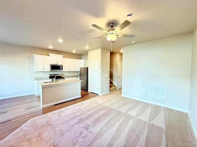 161 Robin Rd, Johnstown, CO 80534 - kitchen with visible vents, a center island with sink, a sink, appliances with stainless steel finishes, and baseboards