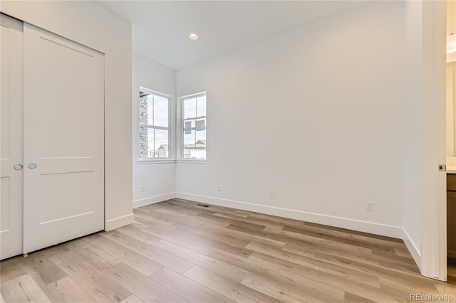 unfurnished bedroom featuring light hardwood / wood-style floors and a closet