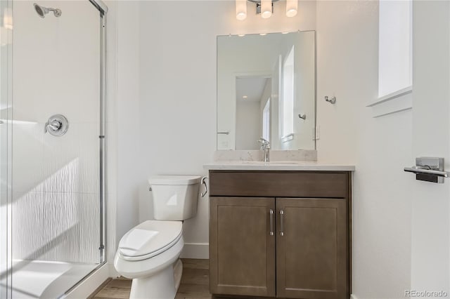 bathroom with wood-type flooring, vanity, toilet, and an enclosed shower