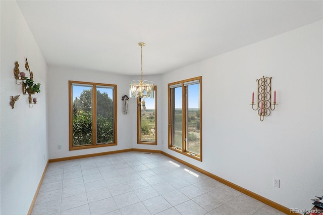 spare room featuring plenty of natural light and an inviting chandelier