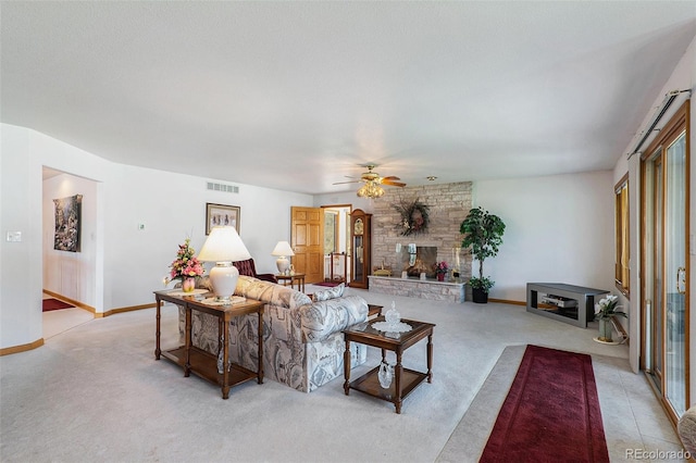 carpeted living room featuring ceiling fan and a fireplace