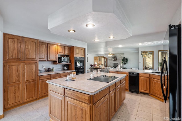 kitchen with light tile patterned flooring, black appliances, ceiling fan with notable chandelier, a kitchen island, and kitchen peninsula