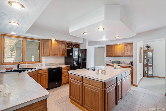 kitchen with light tile patterned flooring, sink, a center island, and black appliances