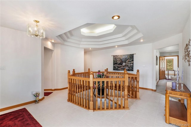 interior space with a tray ceiling and a notable chandelier