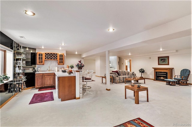 kitchen with a kitchen breakfast bar, sink, and light carpet