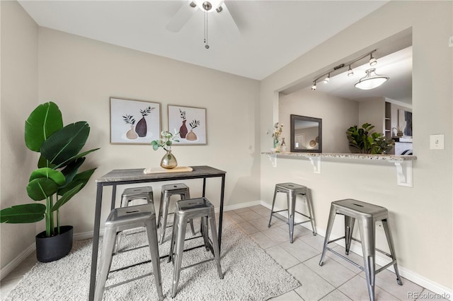 dining area featuring baseboards, light tile patterned floors, and ceiling fan