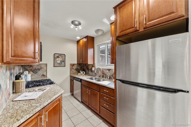kitchen with brown cabinetry, light tile patterned flooring, a sink, backsplash, and stainless steel appliances