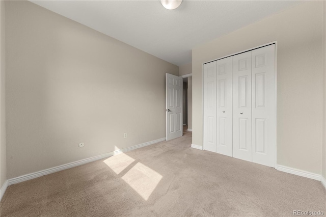 unfurnished bedroom with baseboards, a closet, and carpet