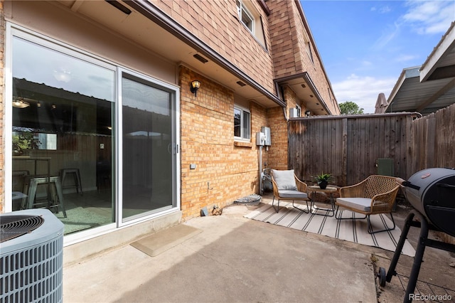 view of patio / terrace featuring central air condition unit and fence
