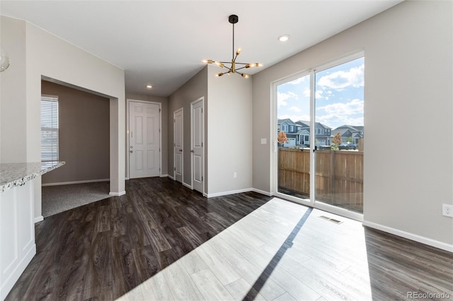 dining area with an inviting chandelier and dark hardwood / wood-style flooring