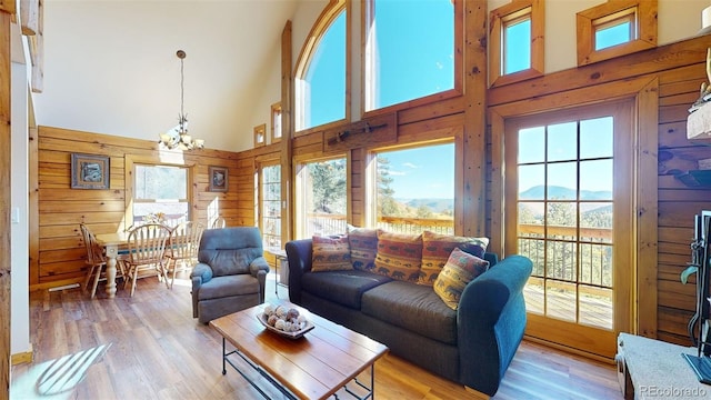 31266 Half Peak Trl, Pine, CO 80470 - living room featuring a chandelier, healthy amount of natural light, a high ceiling, a mountain view, and wooden walls
