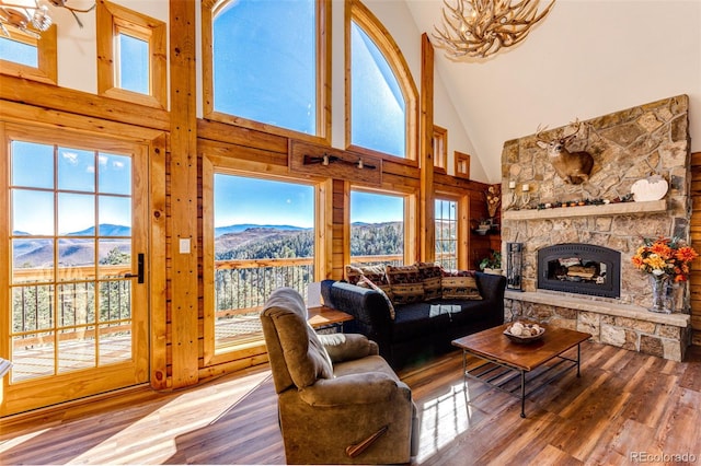 31266 Half Peak Trl, Pine, CO 80470 - living area featuring high vaulted ceiling, a fireplace, a mountain view, wood finished floors, and a chandelier