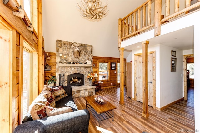 31266 Half Peak Trl, Pine, CO 80470 - living area featuring a towering ceiling, plenty of natural light, wood finished floors, wooden walls, and a fireplace