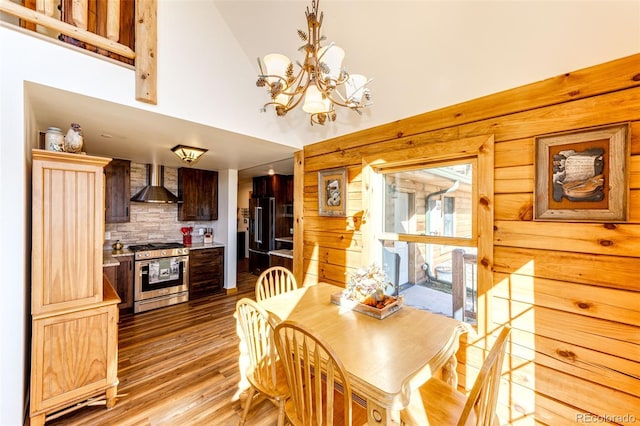 31266 Half Peak Trl, Pine, CO 80470 - dining room with light wood-type flooring, a chandelier, high vaulted ceiling, and wood walls