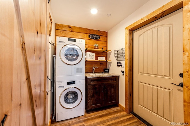 31266 Half Peak Trl, Pine, CO 80470 - laundry area featuring stacked washer and clothes dryer, light wood-style flooring, and cabinet space