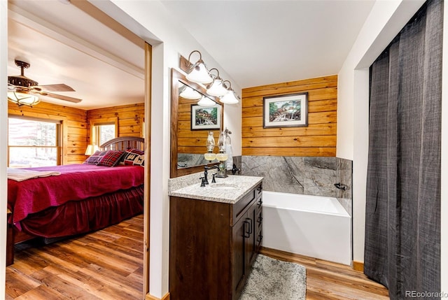 31266 Half Peak Trl, Pine, CO 80470 - bathroom with wood walls, ensuite bath, vanity, wood finished floors, and a garden tub
