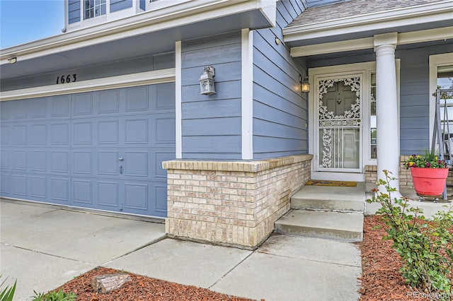 view of exterior entry featuring an attached garage