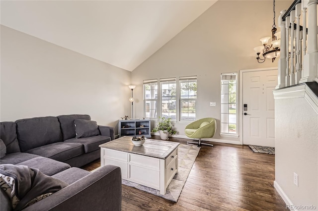living area featuring high vaulted ceiling, a chandelier, dark wood finished floors, and baseboards